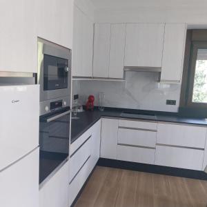 a kitchen with white cabinets and black counter tops at Casa Vista Alegre en Oia in Oia
