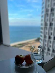 a plate of apples and a glass of water on a table at M1921 Apec Mandala Cham Bay Condotel Mũi Né in Ấp Thiẹn Ái