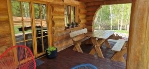 a porch of a wooden cabin with a table and chairs at Sosnowa Chata, Sauna in Jagniątków