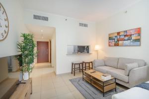 ein Wohnzimmer mit einer Couch und einem Tisch in der Unterkunft Prime Studio in Jumeirah Bay X1 in JLT - Sleeps 2 in Dubai