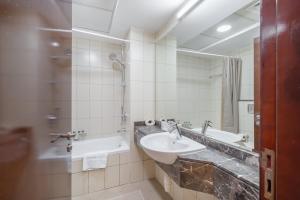 ein Badezimmer mit Waschbecken, Dusche und Spiegel in der Unterkunft Prime Studio in Jumeirah Bay X1 in JLT - Sleeps 2 in Dubai + 37 Fotos