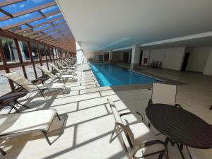 a large swimming pool with chairs and a swimming pool at Suíte Vista Azul - Banheira com vista Pedra Azul in Pedra Azul +15 photos