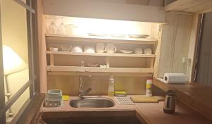 a kitchen counter with a sink and a light above it at Taller de artista in Colonia del Sacramento