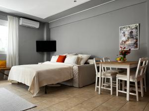 a bedroom with a bed and a table and chairs at Stay & Smile apartments in Kallithea Halkidikis