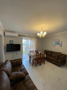 a living room with two couches and a table at Spacious-Central Apartment in Himare
