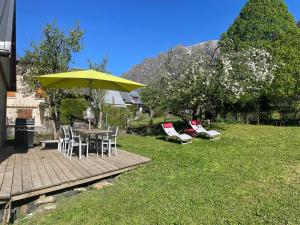 a patio with a table and chairs and an umbrella at Au Cœur des montagnes in La Chalp