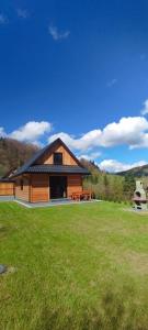 a large wooden building with a picnic table in a field at Domki na Stodoliskach in Kasinka Mala