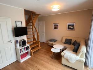 a living room with a couch and a spiral staircase at !!!NEU!!! FEWO Sanna in Dornum