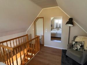 a room with a staircase with a mirror and a bed at !!!NEU!!! FEWO Sanna in Dornum