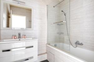 a bathroom with a tub and a sink and a shower at 100m2, Appartement Moderne et Luxueux 6 personnes in Bagnolet +8 photos