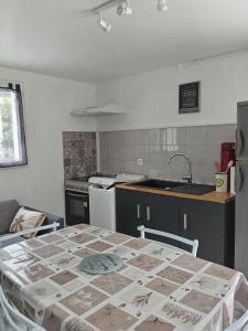 a kitchen with a table and a kitchen with a sink at Location saisonniere in Cozes