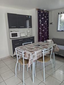a kitchen with a table and chairs in a room at Location saisonniere in Cozes +6 photos