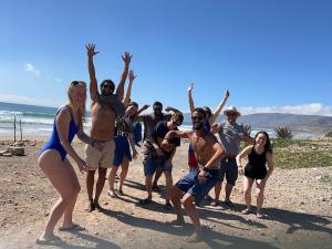 a group of people posing on the beach at Zerisurf House in Taghazout +3 photos