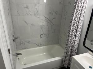 Un baño blanco con bañera y lavabo. en Best Inn, en Wellsville