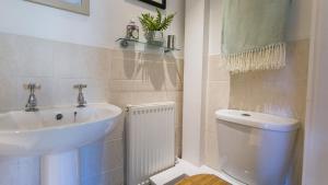 a bathroom with a sink and a toilet at Min y Mor Menai in Menai Bridge +56 photos