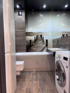 トマシュフ・マゾビエツキにあるApartament Browarna ! Parking 24h free, Netflix free Quick check-inの桟橋の絵が飾られた洗濯室