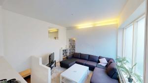 a living room with a couch and a tv at Nimastay - Central Aalborg Haven in Aalborg