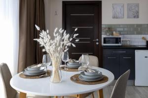 una mesa de comedor blanca con un jarrón de flores en HelloWine Apartman III, en Eger 10 fotos más