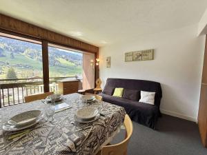 a room with a table and a bed and a window at Appartement 2 pièces cabine avec balcon, proche village et pistes - Praz Sur Arly - 5 pers. - FR-1-603-101 in Praz-sur-Arly