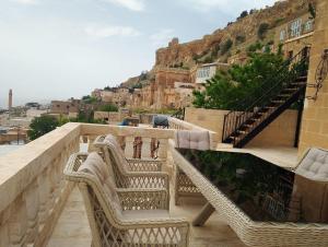 a balcony with wicker chairs and stairs on a building at Mec Konağı in Mardin