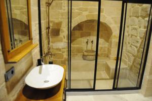 a bathroom with a shower and a white sink at Mec Konağı in Mardin