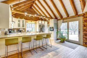 a kitchen with a bar with stools in the middle at 3 Mi to UMass Amherst Peaceful New England Cabin in Sunderland