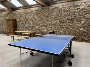 une table de ping-pong dans une pièce avec un mur en pierre dans l'établissement Maison "Ouessant" Pays des Abers, à Plouguerneau