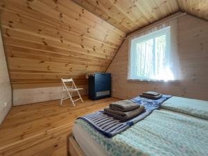 a bedroom with a bed in a log cabin at Na skraju lasu in Kolonia