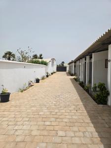 a brick walkway next to a white building at Les Petits Sereres in Cap Skirring