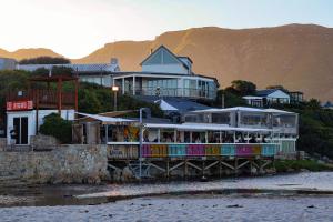 ein Restaurant auf einem Pier direkt am Wasser in der Unterkunft C'estÇa Cottage Modern Luxurious Sounds of the Sea in Hermanus