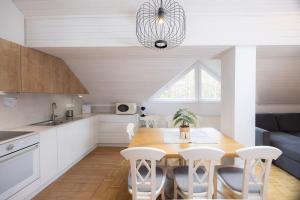 a kitchen and dining room with a table and chairs at Apartma Pehta in Kranjska Gora +13 photos