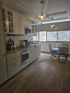 a kitchen with white cabinets and a table and chairs at Imperial Rabat - MAKE IT YOURS in Rabat
