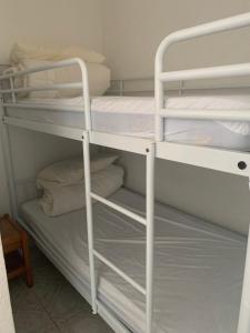a bunk bed with white bunk beds in a room at escapade vue sur le port in Leucate-Plage