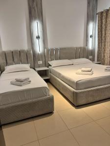 two beds sitting next to each other in a room at Villa Shehu in Ksamil +49 photos