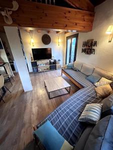 ein Wohnzimmer mit Sofa und Tisch in der Unterkunft Maison cosy, garage, jardin, terrasse vue montagne in Font Romeu Odeillo Via