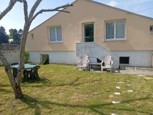 a house with a table and chairs in the yard at Cosy et moderne centre ville Gourin in Gourin