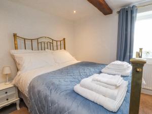 ein Schlafzimmer mit einem Bett mit Handtüchern darauf in der Unterkunft Stoneycross Cottage in Preston