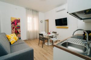 a kitchen and living room with a couch and a table at Casammare faro e sole in Vieste