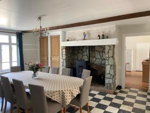 una sala da pranzo con tavolo e camino di Le Domaine du Tronquoi. a Vironchaux
