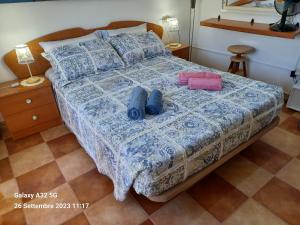 a bedroom with a bed with a blue and white comforter at Habitaciones Gioly in Puerto del Rosario