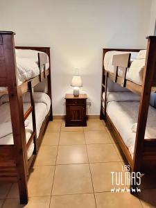 a room with two bunk beds and a table at Las Tulmas Apartamentos Salta in Salta