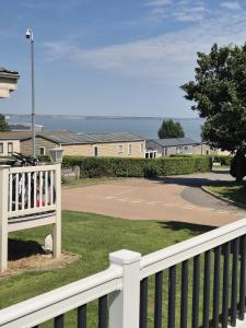 a white fence with a basketball court in a driveway at Thames view at Kent Coast Holiday Park in Allhallows