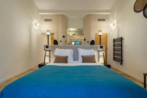 a bedroom with a large bed with a blue blanket at Mas du Couvin, maison d'hôtes en Camargue in Saintes-Maries-de-la-Mer +30 photos