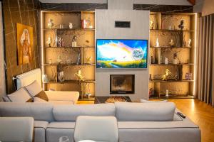 a living room with a couch and a tv at N'Gen Luxury Villas - Razem in Razëm