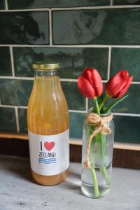 a jar of honey next to a vase of red flowers at Appartement de Schaapskooi in Heinkensand +34 photos