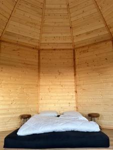 a bed in a room with a wooden ceiling at Camping à la ferme - Hébergements insolites in Cerisy-la-Forêt