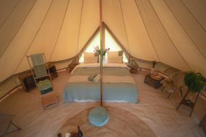 a bedroom in a tent with a bed in it at Boutique tent 'Pruum' op een unieke plek in het groen met luxe bed in Vorden