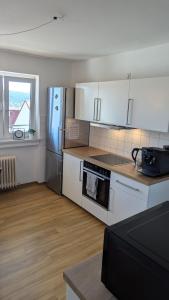 a kitchen with white cabinets and a stainless steel refrigerator at Elegant apartment with dream views in Pforzheim