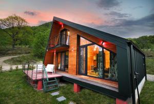 una casa pequeña con terraza y escalera en Green Kub, en Slănic-Moldova