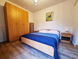 a bedroom with a large bed and a wooden cabinet at Bruno's Rooms in Bašanija +15 photos